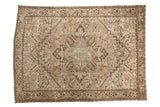 Vintage distressed Mehrivan carpet with a geometric medallion in beige, charcoal, and soft blue accents.