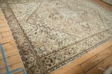 Angled view of a vintage Mehrivan carpet showing time-softened colors and even wear on its geometric pattern.