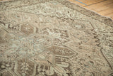 Geometric finials and serrated leaves on the distressed low pile of a vintage Mehrivan carpet.