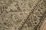 Close-up on the distressed texture and low pile of a vintage Mehrivan rug in sand, charcoal, and dusty slate blue.