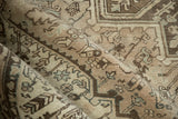 Soft folds on a distressed Mehrivan rug showing its low pile and muted geometric design.