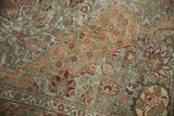 Distressed vintage Bakhtiari carpet with intricate floral arabesques, soft green and terracotta tones.