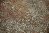 Distressed Bakhtiari rug pile with intricate floral arabesques in terracotta and dusty olive.