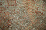 Distressed vintage Bakhtiari rug, intricate floral and stepped patterns in dusty green and terracotta.