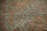 Distressed vintage Bakhtiari carpet with intricate olive, terracotta, and ivory arabesque motifs.