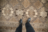 Contrasting guls and pawn design motifs on a distressed vintage Turkish Kars carpet with even wear.