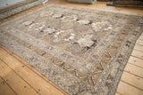 Side angle view of a vintage Kars carpet with a geometric gul field and a pawn design motif border.