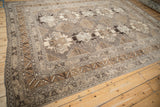 Angled view of a vintage distressed Kars carpet, showcasing its geometric guls and intricate borders.