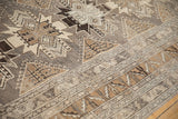 Angled detail of a distressed Kars carpet showing its low pile and geometric pawn motifs.