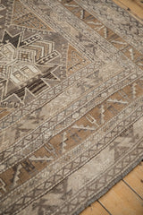 Hand-knotted texture and geometric pawn motifs on a vintage distressed Kars carpet corner.