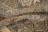 A soft fold in the vintage Kars carpet highlights its worn, low-pile texture and geometric motifs.
