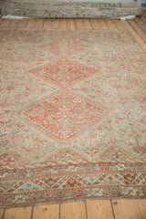 Angled view along the length of a vintage Shiraz rug, highlighting its distressed, low-pile texture.