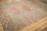 Angled view of the distressed pile and geometric border on a vintage Persian Shiraz carpet.