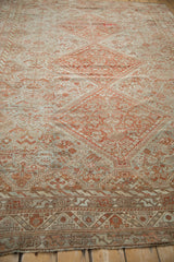 Angled view across the distressed, low-pile surface of a vintage Shiraz carpet.