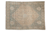 Vintage distressed Qashqai carpet with a diamond medallion design in soft sand and dusty slate blue tones.