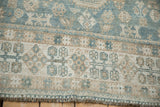 Worn, hand-knotted texture of a Qashqai carpet in pale slate blue and sand.