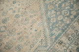 Distressed low-pile texture and visible knot heads of a vintage Qashqai rug in sand and blue.