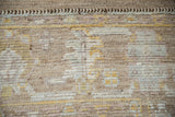Distressed Afghani Oushak rug detail: visible knot wear, pale multi-tones, and chevron band.