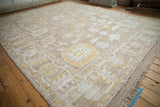 Distressed Afghani Oushak design carpet, showing wear across palmettes and serrated leaf border.