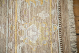 Distressed Afghani Oushak design carpet detail with worn pile, visible foundation, original selvage, and fringe.