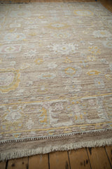 Distressed Afghani Oushak rug fringe, woven chocolate brown selvage, and muted floral border.