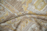 Distressed Afghani Oushak carpet texture with worn knot heads, visible foundation, and muted sand, saffron, mauve.