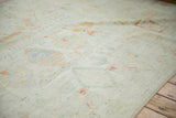 Soft pile texture of a distressed Afghani Moroccan carpet, showing faded ivory, jade green, and madder red motifs.