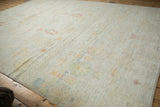 Distressed Afghani Moroccan carpet's textured pile with faded saffron, ivory, and pale jade plant motifs.