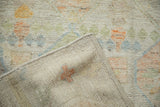 Distressed Afghani Moroccan rug pile with faded saffron, jade, and blue hues, revealing hand-knotted reverse.