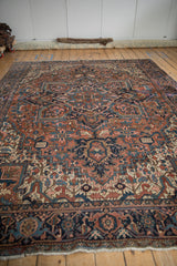 Vintage Heriz border with navy blue turtle samovar motifs, brick red field, and fringe.