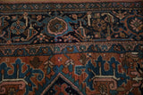 Vintage Heriz carpet's navy turtle samovar border meets brick red field with geometric florals.