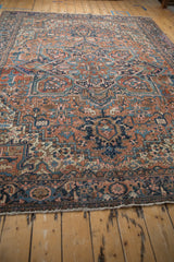 Brick red and navy blue turtle samovar border with fringed edge on Heriz carpet.