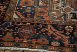 Vintage Mehrivan rug's hand-knotted navy border featuring brick red floral motifs and ivory fringe.
