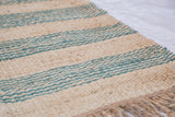 Handmade Emmy Collection pure jute rug, showing coarse natural beige and teal striped texture, plus fringe.