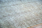 Distressed texture and faded tone-on-tone floral motifs on a vintage Oushak rug.