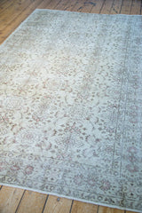 Distressed ivory pile of the vintage Turkish rug showcasing faded tone-on-tone floral patterns.