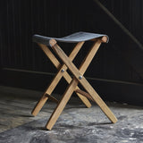 Peg and Awl Expedition Stool, reclaimed oak X-frame, slate gray canvas seat.