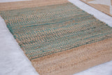 Detail of the handmade Gemma jute rug showing vibrant turquoise and natural horizontal stripes.
