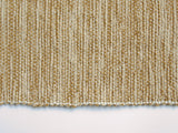 Undulating gold and cream handwoven texture of the table runner with a surged hem.