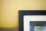 Vintage-style textured black finish on the corner of a sleek handmade frame.