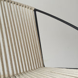 Hand-woven natural cotton cording connecting to the black metal frame of the Hoop Chair.
