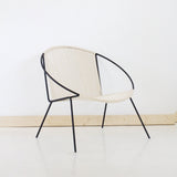 Curved black steel frame and hand-woven natural cotton cording of the chair.