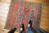 Hand-knotted vintage rug with rust red, light blue geometric motifs and tribal animals.