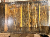 Distressed reclaimed wood planks and dark iron banding of the coffee table top.