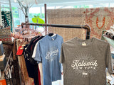 Katonah New York t-shirts in heather gray and blue hanging on a store display rack.