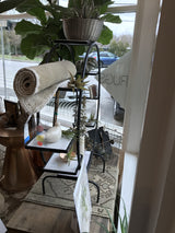Multi-tiered vintage round plant stand display with black metal and white marble.