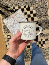 White enamel Katonah New York coffee mug with state outline logo.