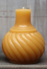 Golden yellow beeswax candle with a prominent swirl pattern, shaped like an antique inkwell.