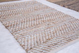 Close-up of Juliette rug's natural jute and recycled leather with beige and pale grey chevron.