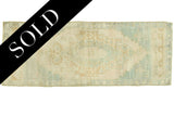 Vintage Oushak rug bottom corner with blanched ivory, seafoam, and gold pattern.